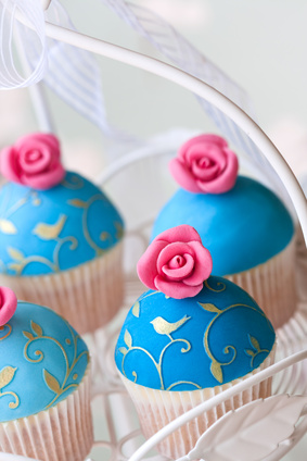 Cupcakes mit blauer Haube und Rose