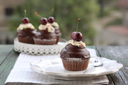 Cupcakes mit Schokoladen-Frosting und Kirschen